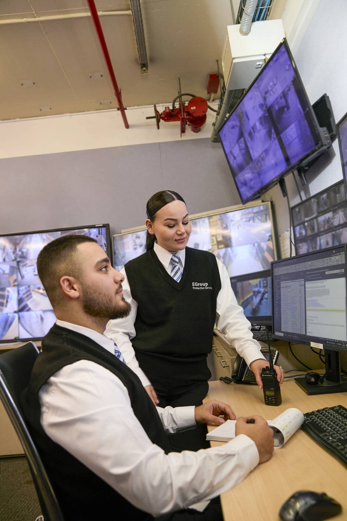 Security team in a control room monitoring CCTV feeds
